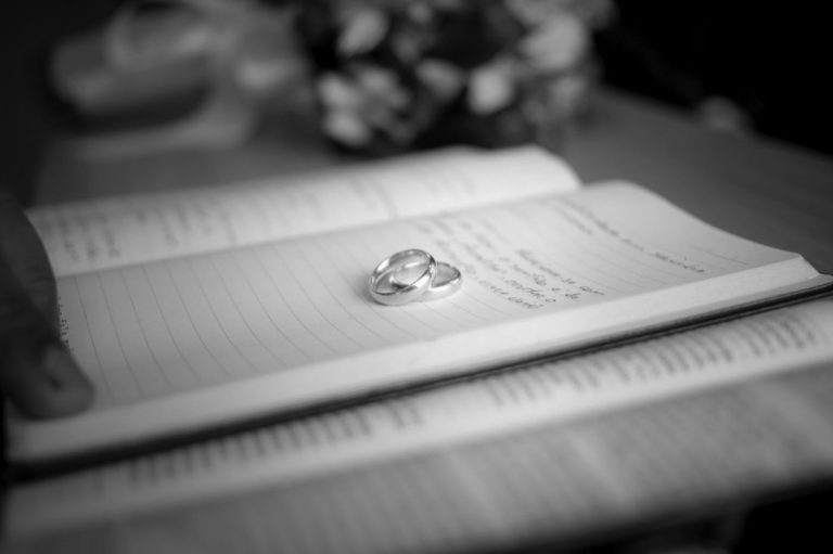 Deux alliances posées sur un registre, illustrant le coût d'une procédure de divorce