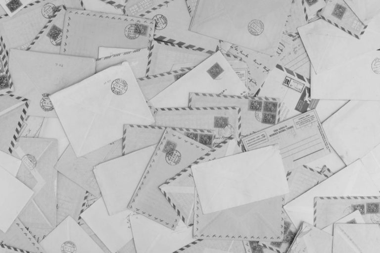 Courriers et enveloppes accumulés évoquant des relances pour loyers impayés
