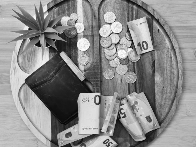 Billets, pièces et portefeuille posés sur une table