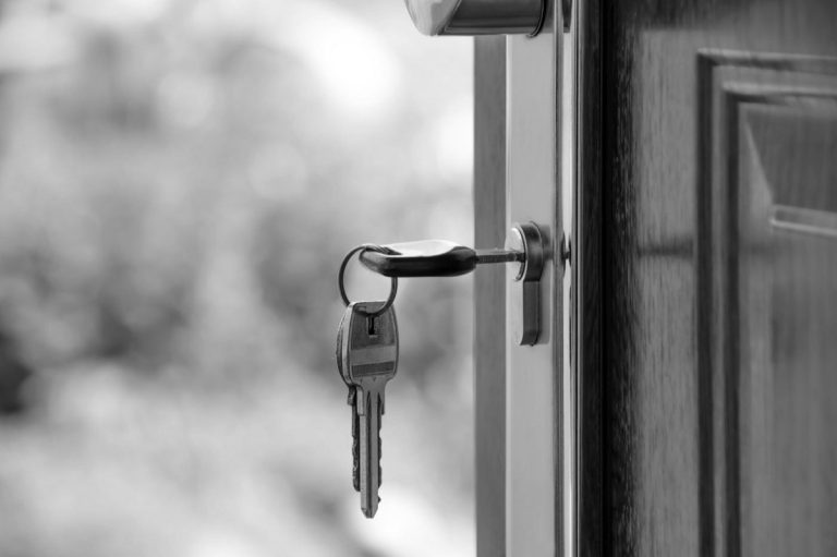 Clés dans la serrure d'une porte d'habitation, évoquant la protection du domicile