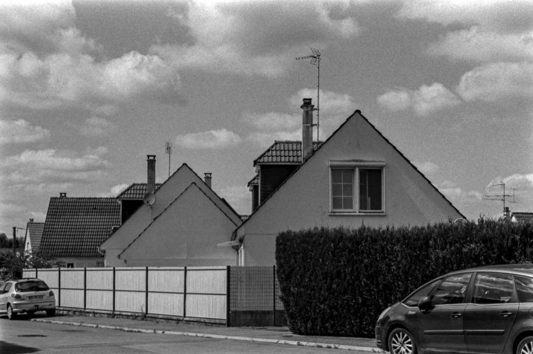 Maisons voisines séparées par une haie et une clôture dans un quartier résidentiel